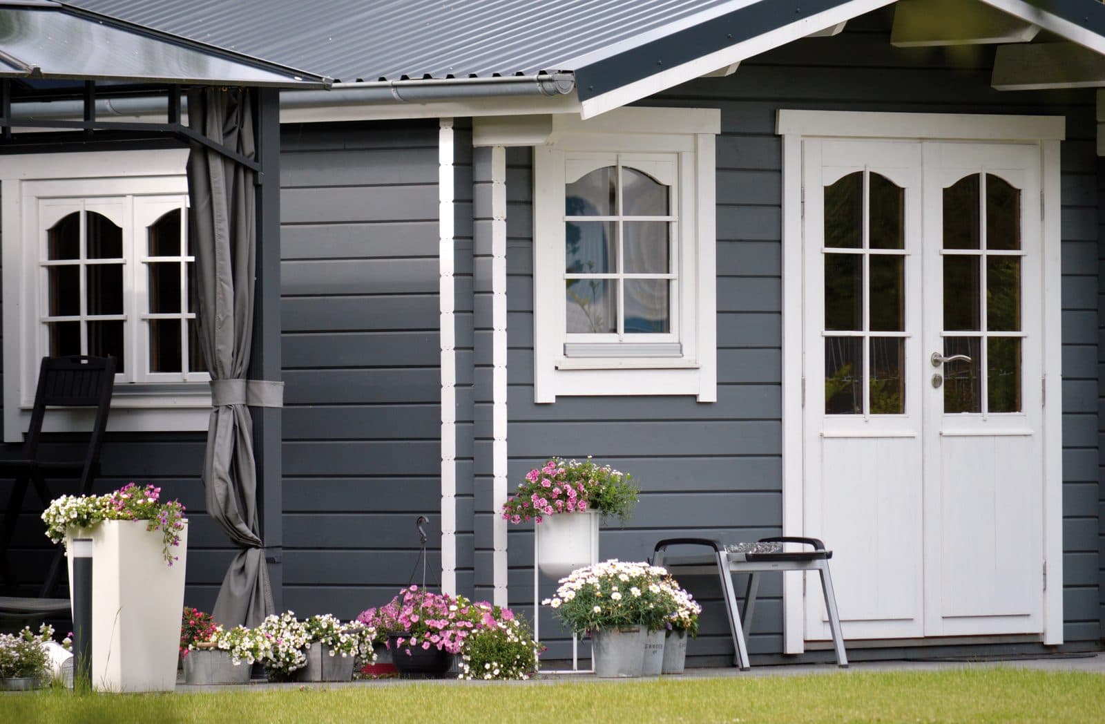 Grey and white timber garden room with French doors and flower planters